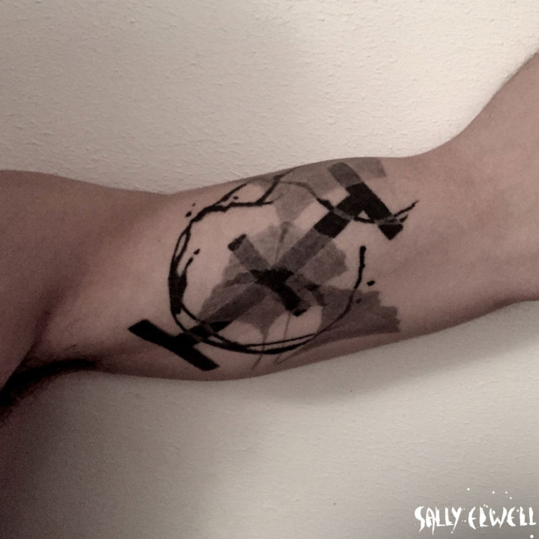 Tatouage biceps Gingko superposition transparence nuances de gris et noir.