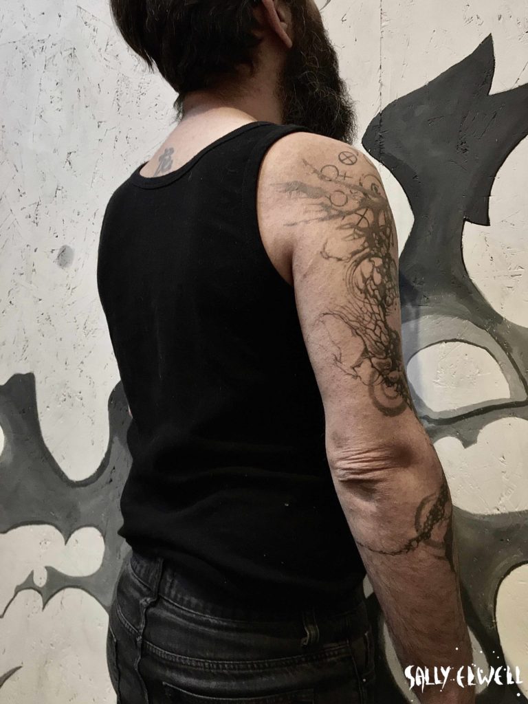 Tatouage bras phénix symboles alchimie dentelle organique encre noire et dégradé de gris