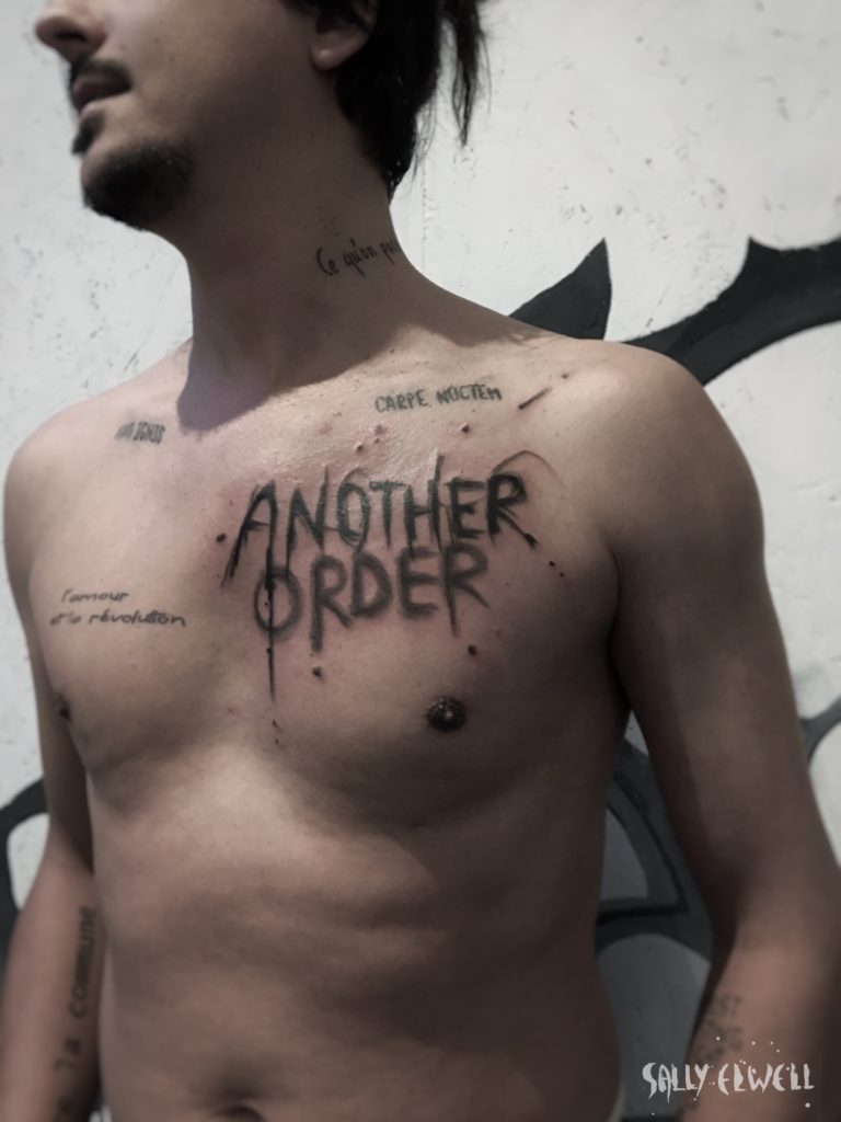 tatouage pectoral lettrage superposition encre noire et grise