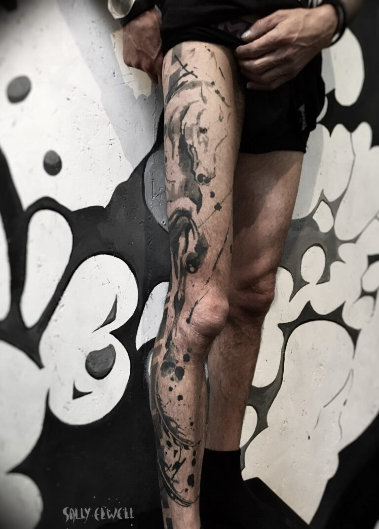 tatouage jambe cheval plumes graphique tache dentelle organique encre noire dégradés de gris