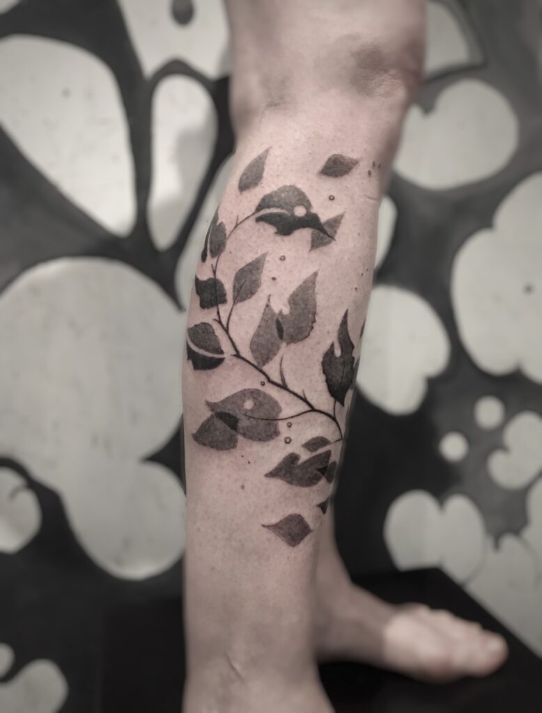 tatouage jambe branche feuillue