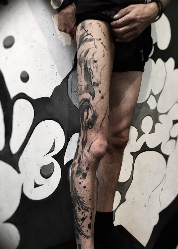 tatouage jambe entière cheval, plumes + graphismes en dégradés de gris face
