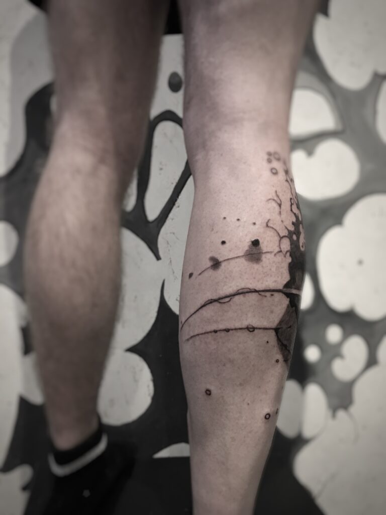 tatouage jambe plongée dans les profondeurs encre noire et dégradés de gris arrière