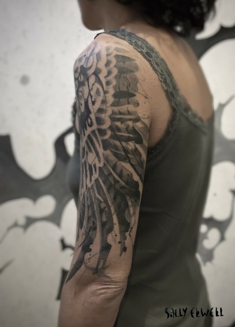 tatouage épaule bras ailes de buse encre noire et dégradé de gris tatouage épaule bras ailes de buse encre noire et dégradé de gris