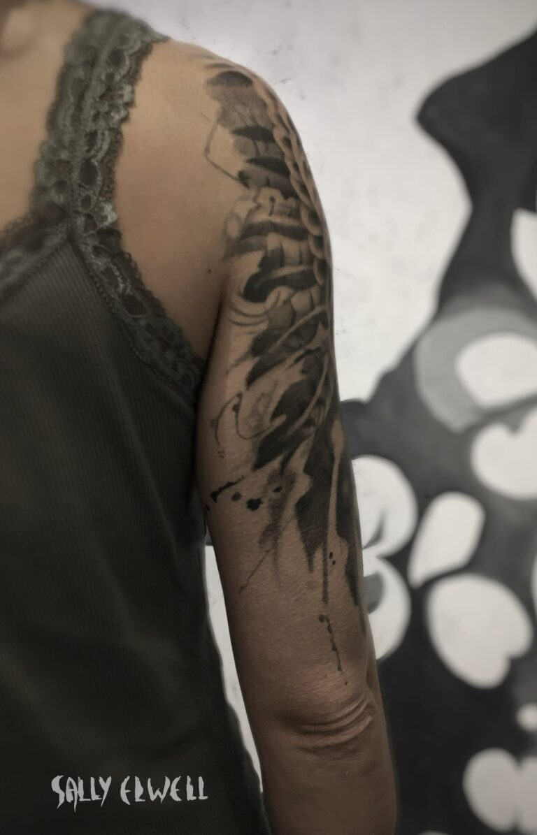 tatouage épaule bras ailes de buse encre noire et dégradé de gris tatouage épaule bras ailes de buse encre noire et dégradé de gris