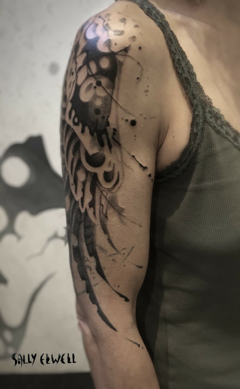 tatouage épaule bras ailes de buse encre noire et dégradé de gris tatouage épaule bras ailes de buse encre noire et dégradé de gris