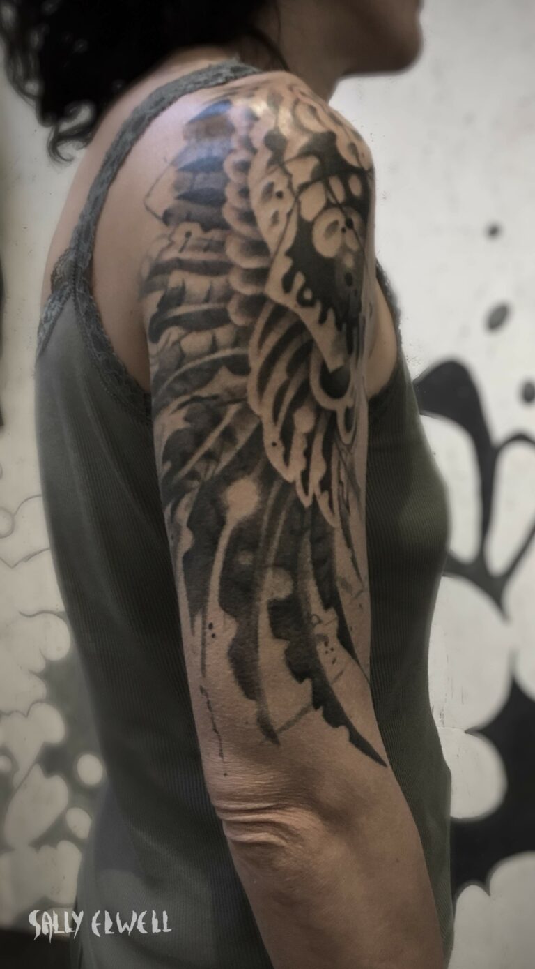 tatouage épaule bras ailes de buse encre noire et dégradé de gris tatouage épaule bras ailes de buse encre noire et dégradé de gris